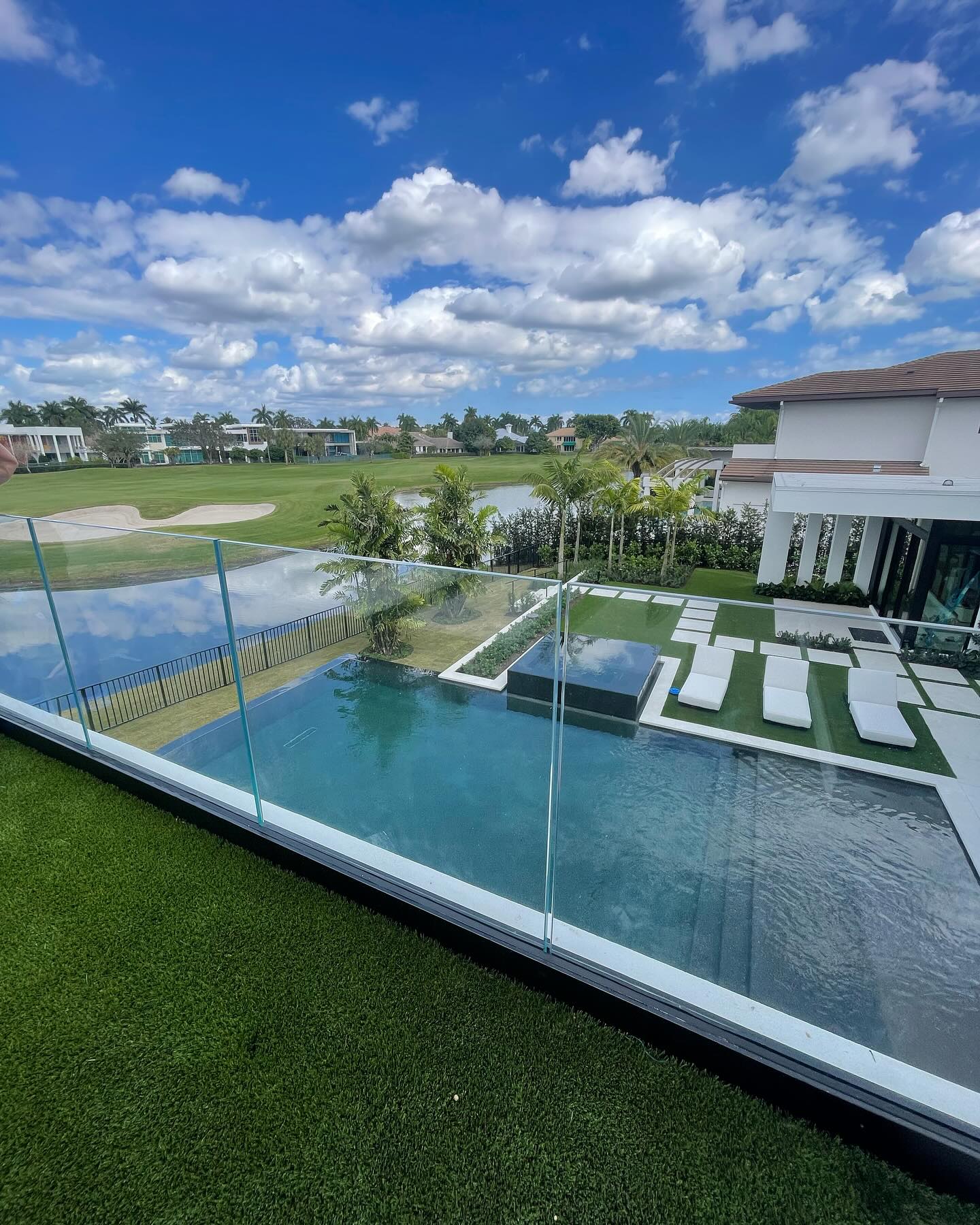 Custom glass safety railing surrounding a residential pool