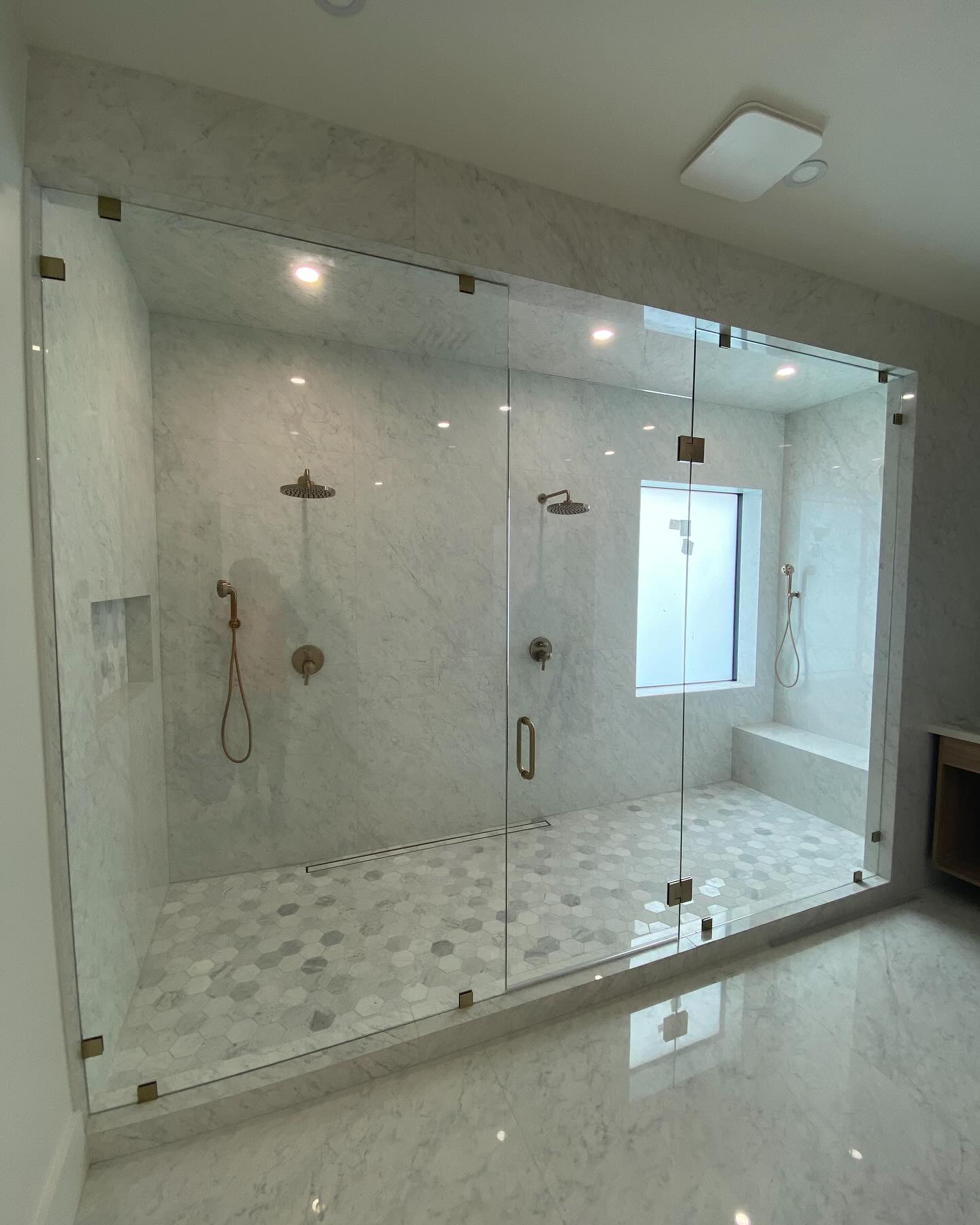 Bright white bathroom with a custom glass shower enclosure
